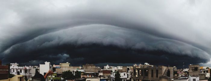 Aerial view of townscape against dramatic sky