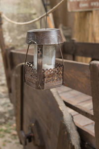 Close-up of electric lamp hanging on wood