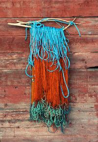 Close-up of fishing net hanging on wooden wall