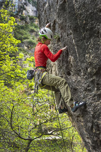 Woman rock climbing in forest