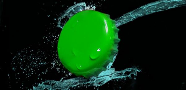 Close-up of water drops on ball against black background