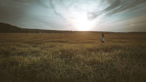 Man standing on field against bright sky