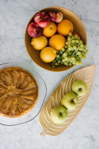 Fresh juicy fruit in a vase on the kitchen table, apples, peaches, grapes, oranges, lemons