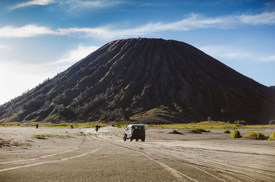 Off-road vehicle driving and riding motorcycles by volcano in desert