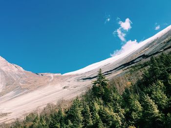 Scenic view of mountains against blue sky