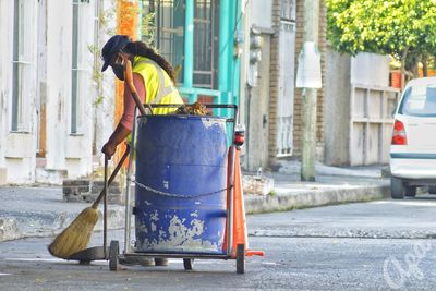 Man working on footpath by street in city