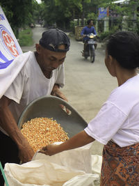 Men collecting corns in sack