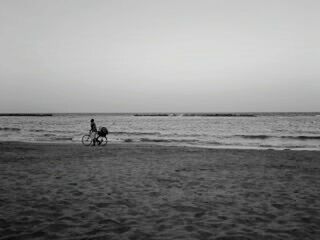 MEN RIDING HORSE ON BEACH