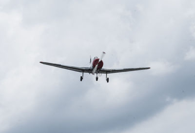 Low angle view of airplane flying against sky