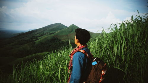 Rear view of woman looking at mountain against sky