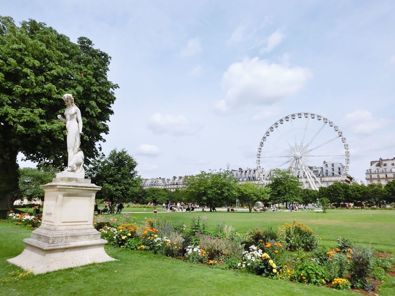 tree, grass, architecture, built structure, sky, park - man made space, famous place, travel destinations, green color, tourism, formal garden, cloud - sky, international landmark, travel, arts culture and entertainment, sculpture, art and craft, park, ferris wheel, monument