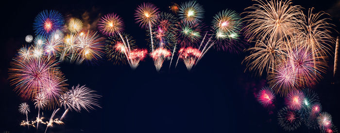 Low angle view of firework display at night