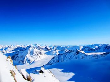 Scenic view of snowcapped mountains against clear blue sky