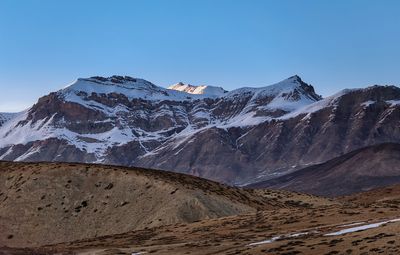 Scenic view of snowcapped mountains against clear blue sky