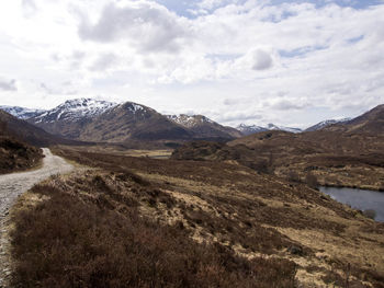 Scenic view of mountains against cloudy sky