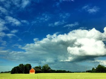 Scenic view of field against cloudy sky