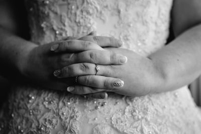 Midsection of bride with hands clasped during wedding ceremony