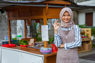 Portrait of smiling young woman standing at home