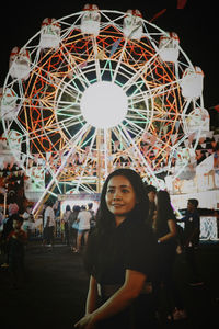 Portrait of smiling young woman standing at night