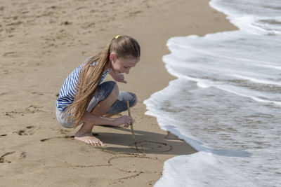 Girl carving on shore at beach