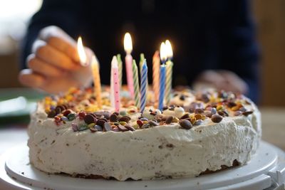 Midsection of person putting candles on birthday cake