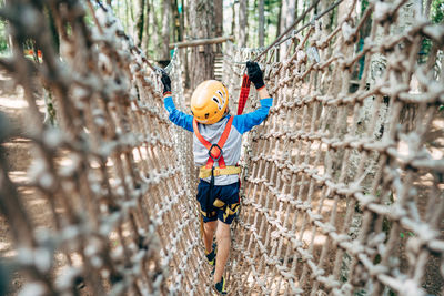 Full length of man with arms raised in forest