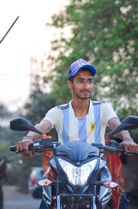 Portrait of man riding motorcycle on road