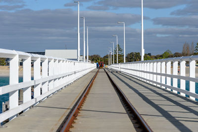 People on footpath amidst bridge against sky