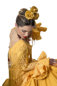 Woman wearing yellow traditional clothing while crouching against white background