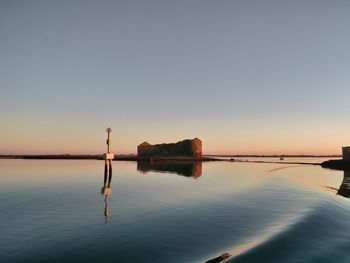 Scenic view of lake against clear sky during sunset