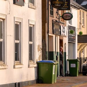 Man walking on footpath by building