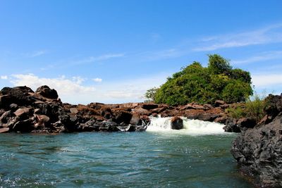 Scenic view of rocks in sea against sky