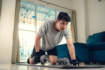 Low angle view of man exercising at home