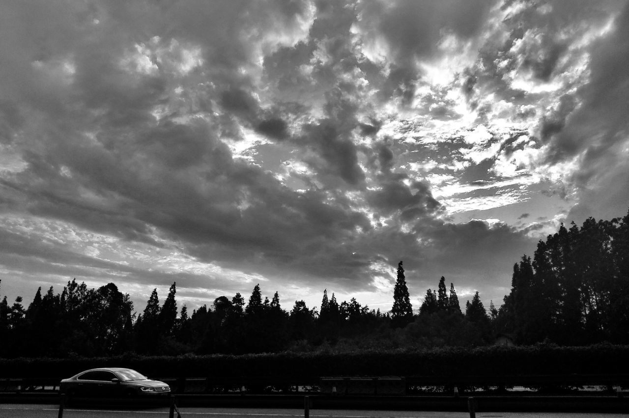 sky, cloud - sky, tree, transportation, cloudy, land vehicle, mode of transport, car, cloud, weather, landscape, tranquility, tranquil scene, nature, scenics, field, beauty in nature, silhouette, overcast, road