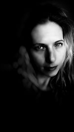 Portrait of beautiful woman against black background