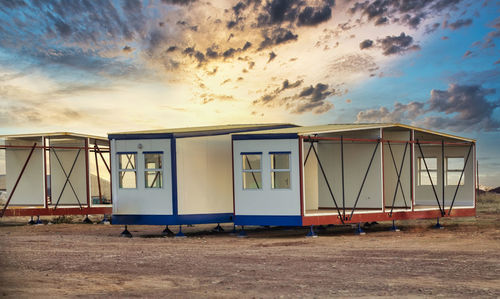 Lifeguard hut on beach against sky during sunset