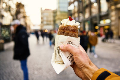 Cropped hand of person holding trdelnik, traditional czech sweet. 