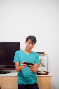 Smiling man using mobile phone