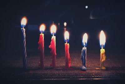 Close-up of burning candles on wooden table