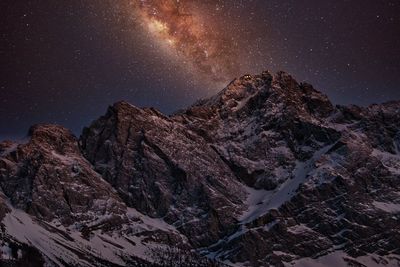 Scenic view of snowcapped mountains against sky at night