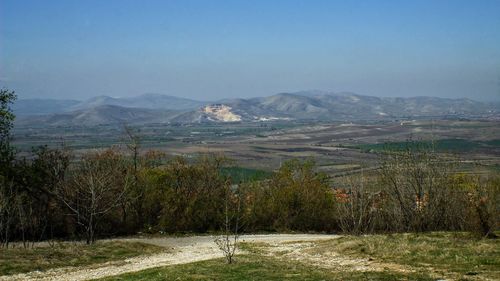 Scenic view of landscape and mountains against clear sky
