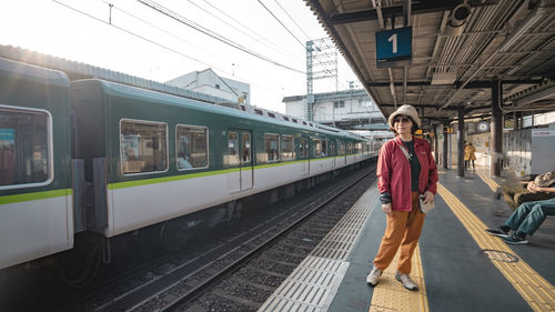 Rear view of woman walking on railroad station