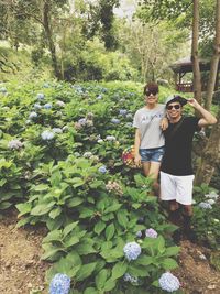 Portrait of young couple standing by plants