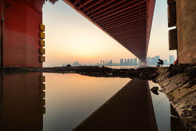 Bridge over river in city against sky