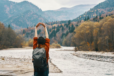 Rear view of man standing on riverbank