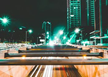 Illuminated light trails in city against sky at night