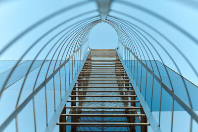 Fire escape staircase. long metal staircase on blue glass facade of building. emergency fire exit