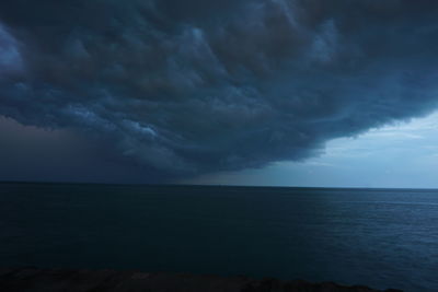 Scenic view of sea against storm clouds