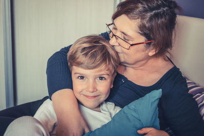 Grandmother kissing grandson on bed