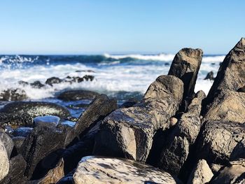 Panoramic view of rocks on beach against sky